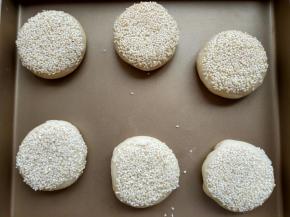 18. 依次完成剩下五份，按扁，表面刷一层水或者蛋液或者黄油，我刷的水，所以烤完的火烧偏白，刷完水，粘层芝麻，码入金盘 放入预热好的烤箱，上下火180度中下层18分钟