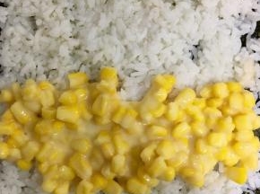 将混合好的炼乳玉米粒铺在米饭的下端，开始卷起的地方
