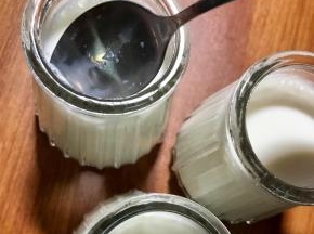剩下的酸奶加入一大勺糖，或者根据喜欢的甜度调味。搅匀后过滤罐装小瓶，用勺子轻搅表面的气泡让其消失。