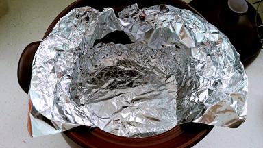 裁两张比锅体大的锡纸备用。锡纸放入锅内，一圈用手按压贴牢砂锅内壁，顶部包住砂锅边沿。