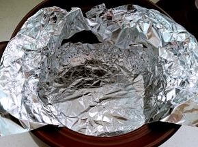 裁两张比锅体大的锡纸备用。锡纸放入锅内，一圈用手按压贴牢砂锅内壁，顶部包住砂锅边沿。