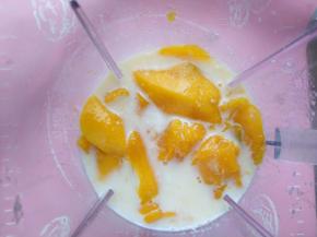 将冷却后的牛奶+芒果丁放入搅拌机，打成糊状