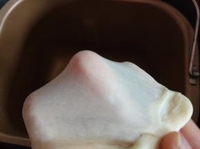 将披萨饼皮的食材全部放入面包机中，揉至出手套膜