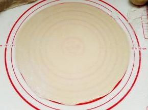 先取1个擀皮，其他的用湿布盖着防干皮。用小擀面杖擀成大小合适的圆形。