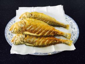 把煎好的鱼用厨房用纸吸一下油。