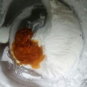 将打发好的淡奶油1/2加入果泥，搅拌均匀。