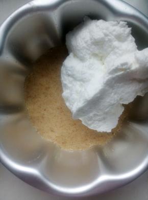 原味饼干倒入六寸模具用勺子压平，压实。将原味奶油的一半倒入压平的饼干屑上。用刮刀抹平。