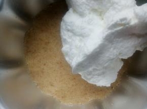 原味饼干倒入六寸模具用勺子压平，压实。将原味奶油的一半倒入压平的饼干屑上。用刮刀抹平。