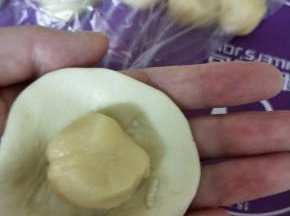 取一份油皮擀圆，包入油酥，收口捏紧，12份依次包好