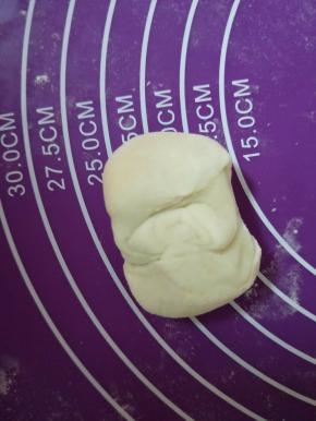卷好的面团两头向中间收口，按扁
