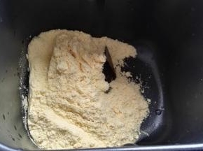 玉米面倒容器中（本来想蒸玉米面窝头，临时改变主意做饼，感觉量多馒头机和不下又倒出用手揉的）。