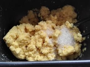 边倒开水(开水300g)边用筷子搅拌，至无干粉，倒入白糖趁热融化（白糖可以直接倒玉米面中一起烫），冷至手温。