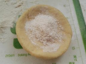 取一个面剂，擀成边薄里厚的圆片，放白糖馅(我是两手转圈把边捏薄，习惯了。)