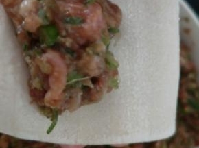 肉馅放在馄饨皮较短的一边