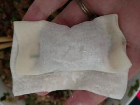 把皮卷起来包住肉馅，两边捏紧