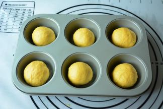 将面团分割6等份，滚圆盖上保鲜膜松弛15分钟。松弛好的面团放入模具中继续发酵至两倍大。