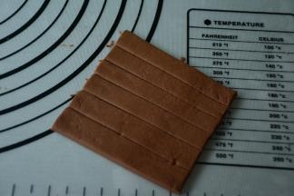 接着开始做巧克力饼干面团和原味饼干面团。（此食谱配方省略，多余的饼干面团可以自主创意做饼干。）用擀面杖将巧克力饼干团擀薄，用刮板切出长条做眼镜带。