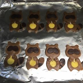 眼睛是深咖啡色面片印出来的，条纹间隔的面片印出小浣熊尾巴，小圆圈印出小熊的小手，再用葵花籽沾一点蛋液放在小熊两手之间。烤箱预热180度，上下火，中上层先烤5分钟以后，盖上锡箔纸继续烤10分钟