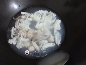 6. 锅里坐水烧开，鱿鱼用开水先烫一烫，鱿鱼卷起即可，捞出过冷水备用