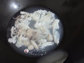 6. 锅里坐水烧开，鱿鱼用开水先烫一烫，鱿鱼卷起即可，捞出过冷水备用