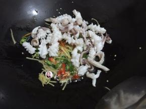 9. 倒入鱿鱼翻炒几下