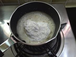 4. 加热好的玉米油关火，倒入过筛好的低筋面粉
