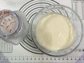 15. 用手动打蛋器从底部向上拌起，拌至顺滑细腻的程度，事先准备好裱花袋用一个杯子把袋子装好，以免倒蛋黄糊时手忙脚乱的