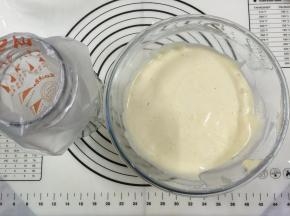 15. 用手动打蛋器从底部向上拌起，拌至顺滑细腻的程度，事先准备好裱花袋用一个杯子把袋子装好，以免倒蛋黄糊时手忙脚乱的