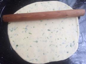 揉好的面团，用擀面杖擀开成薄饼状态。