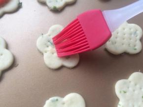 蛋黄加入几滴水打散，在饼干中心点扫上一点点蛋黄液。