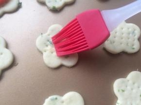 蛋黄加入几滴水打散，在饼干中心点扫上一点点蛋黄液。