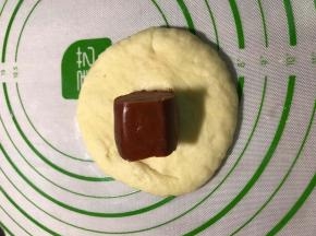 用手掌按扁排除气泡，放入一颗火腿肠，包好收口。