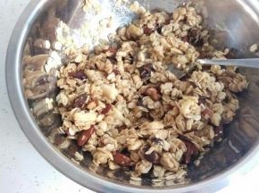再把离火的糖浆迅速倒入麦片中。搅拌均匀。每个都要粘到糖浆，不然后期不会固定。