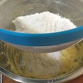 低粉和泡打粉混合物，过筛。先筛入1/3的干粉，使用橡胶拌刀成J字形搅拌。此时的混合物比较干。