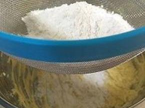 低粉和泡打粉混合物，过筛。先筛入1/3的干粉，使用橡胶拌刀成J字形搅拌。此时的混合物比较干。