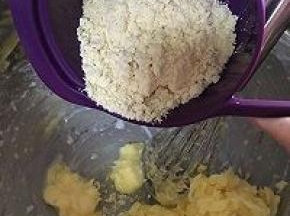 将玉米粉一次性加入到盆中，用打蛋器充分搅拌均匀。