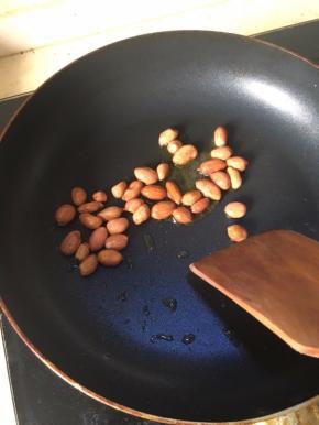 在锅中加入少量菜油，热油后，小火，加花生粒炸。
