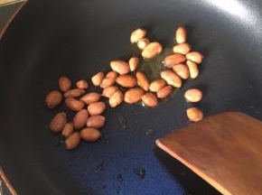 在锅中加入少量菜油，热油后，小火，加花生粒炸。