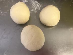 发好的面再次排气，将揉好的面团分成若干份儿, 每份儿都揉成圆形。