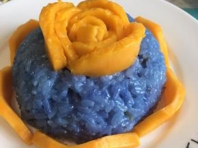 做一朵芒果花在糯米饭上，周边围上一圈芒果