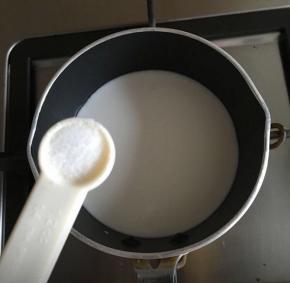 椰浆倒入小奶锅内，开小火，加入1/4茶匙盐