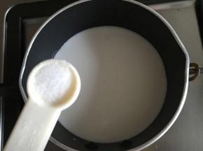 椰浆倒入小奶锅内，开小火，加入1/4茶匙盐