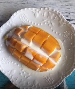 另取一个芒果切开不去皮，用小刀横竖划几刀，但是不要切断，浇上剩下的椰浆