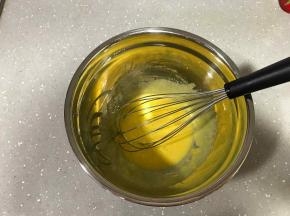 8、将加了柠檬皮屑的白砂糖倒入蛋黄，用手动打蛋器快速搅拌打发，直到颜色发白。