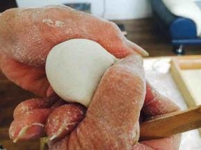 先将饺子皮对折，中间捏紧，然后用双手的拇指和食指将饺子皮的边向中间轻轻挤压。