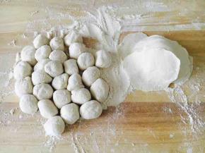 拿出面团再把它们揉匀，取一块小块面团（其它的放回盆里保存），把它用双手搓成长条，再揪成小圆剂子，把小圆剂子压平，擀成饺子皮，擀饺子要中间厚边薄。