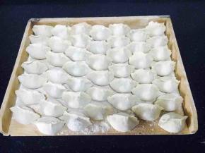 把包好的饺子整齐的码放在饺子板上。
饺子板上要提前均匀地撒些面粉，避免饺子和饺子板粘连。