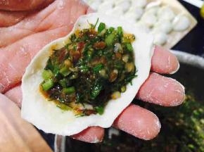 往饺子皮上放适量的饺子馅。