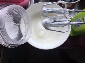 然后用打蛋器打出鱼眼后倒入一半糖粉用打蛋器继续打发