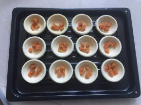 蛋挞皮放入烤盘里，将蒸好的红薯放入蛋挞皮中